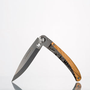 Couteau de poche inox bois d'olivier — fermé sur fond clair, fabriqué en France